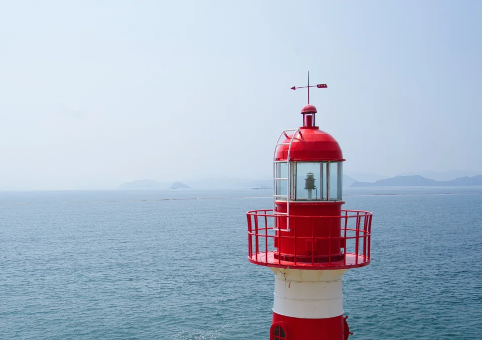 A lighthouse and wind vane overlooking the sea