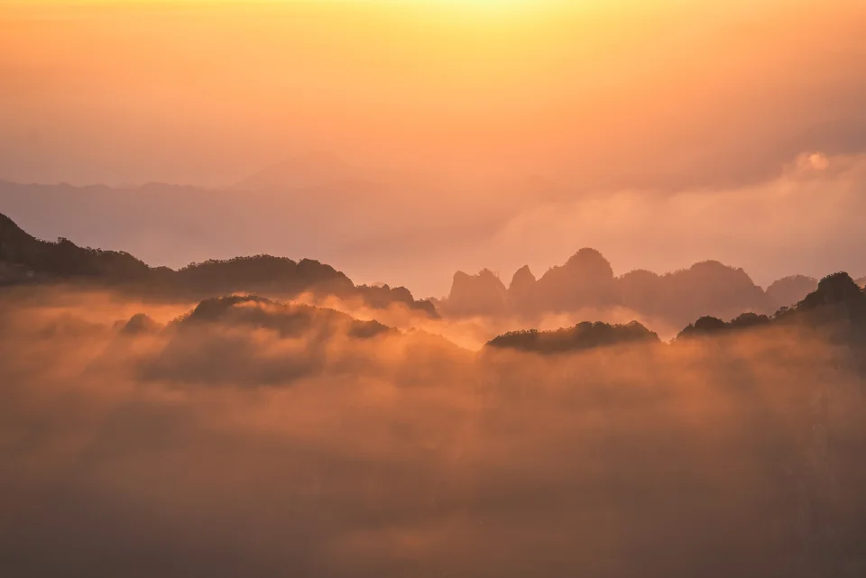 Morning light breaking over layered mountain ridges